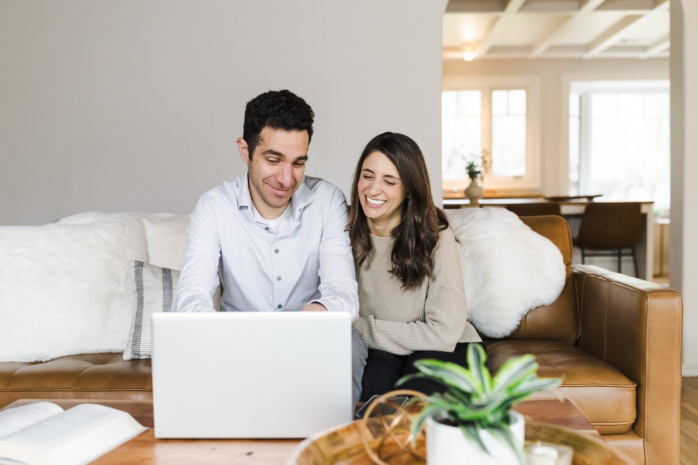 Erez Druk and Dr. Gabriela Meckler laughing at a laptop on a couch
